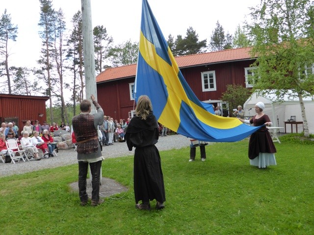 Svenska flaggan bärs framför gårdens nationaldagspublik